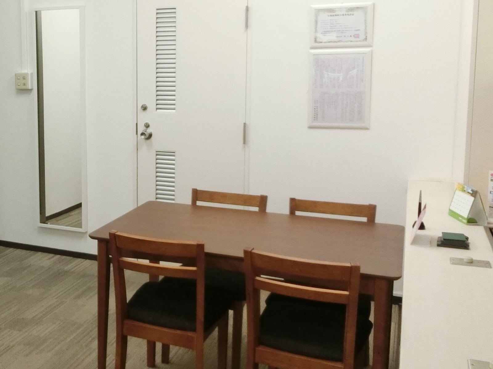 打合せ用のテーブルと椅子、壁には宅地建物取引業の免許証
